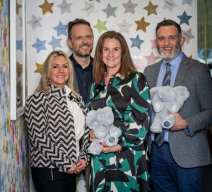 Two men and two women standing in front of a starry background