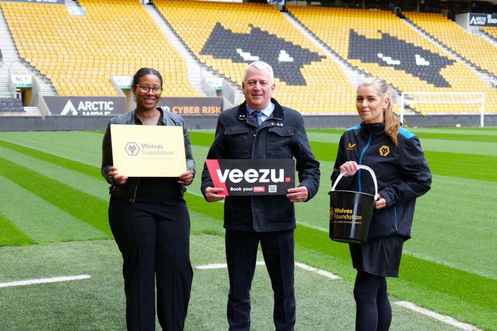 Three people standing on a football pitch