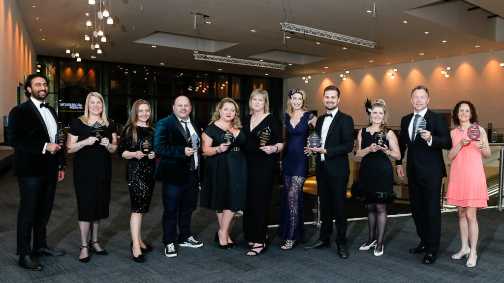 A group of people standing with awards