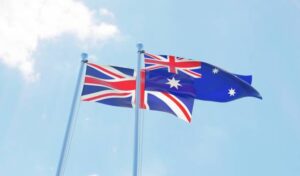 UK and Australia, two flags waving against blue sky.