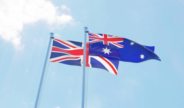 UK and Australia, two flags waving against blue sky.