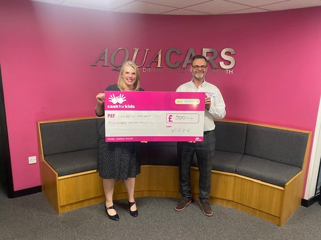 Two people standing with a big cheque