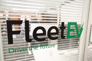 An image of the FleetEV logo against an office window.