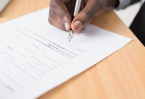 A hand holding a fountain pen filling in a survey.